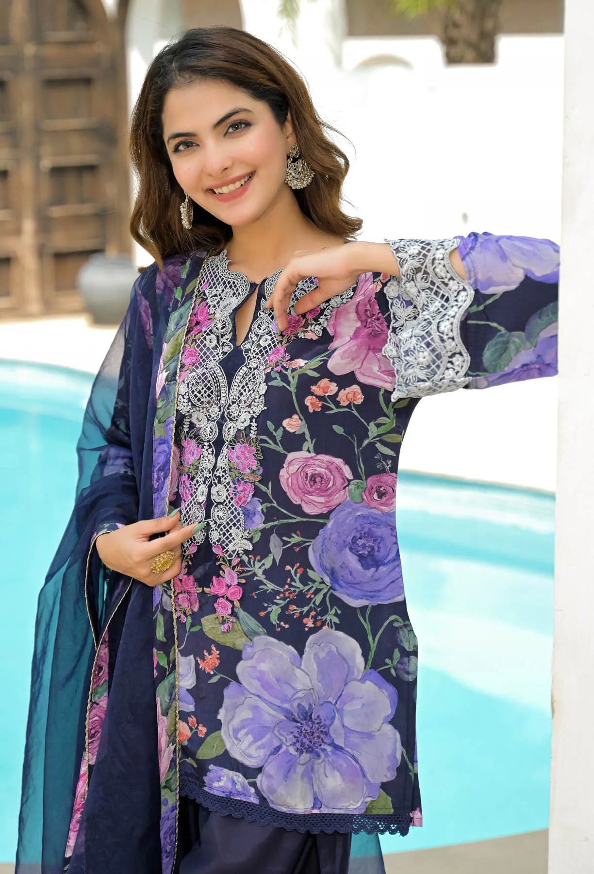 Woman wearing a floral dress with a pool in the background