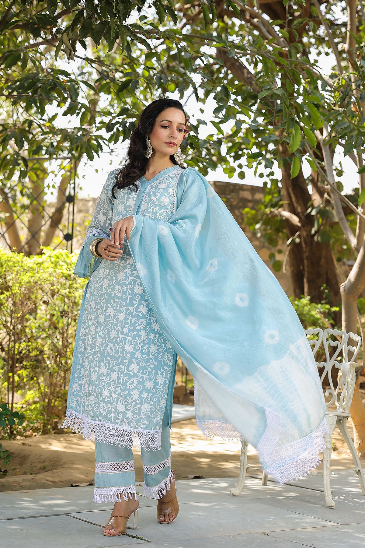 Woman in a light blue traditional outfit with a matching dupatta in a garden setting