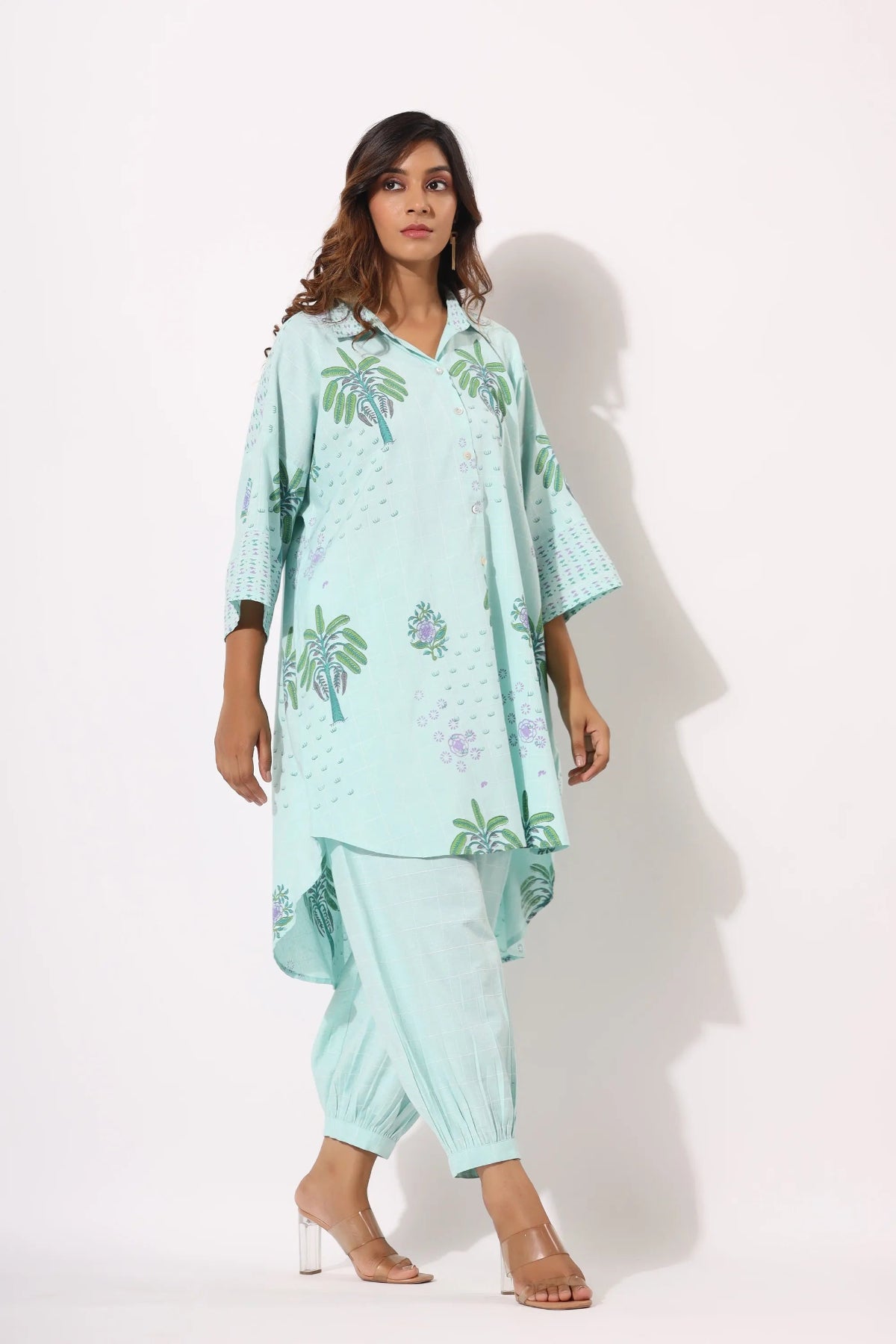 Woman wearing a light blue floral outfit on a white background