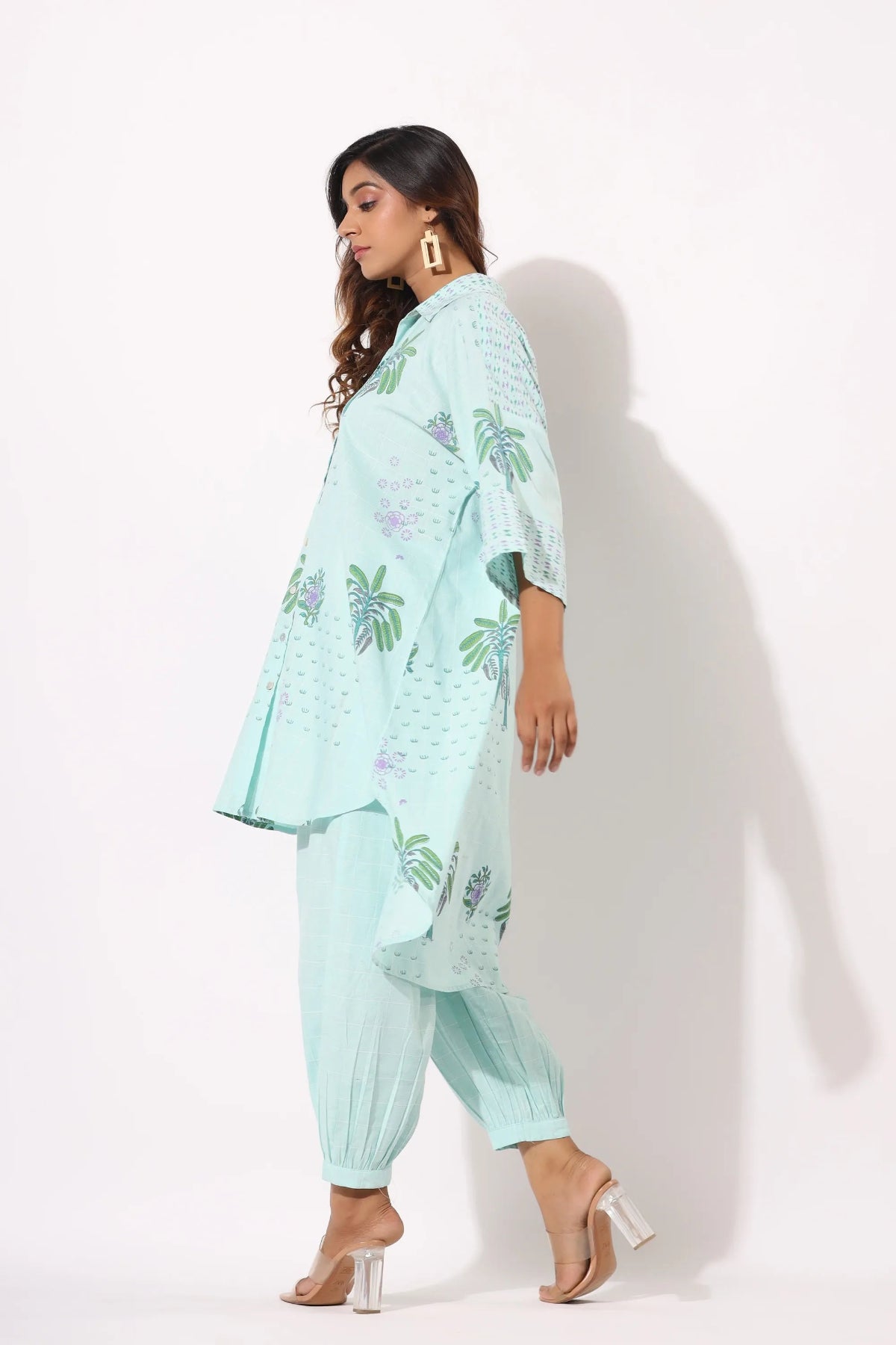 Woman wearing a light blue floral outfit on a white background