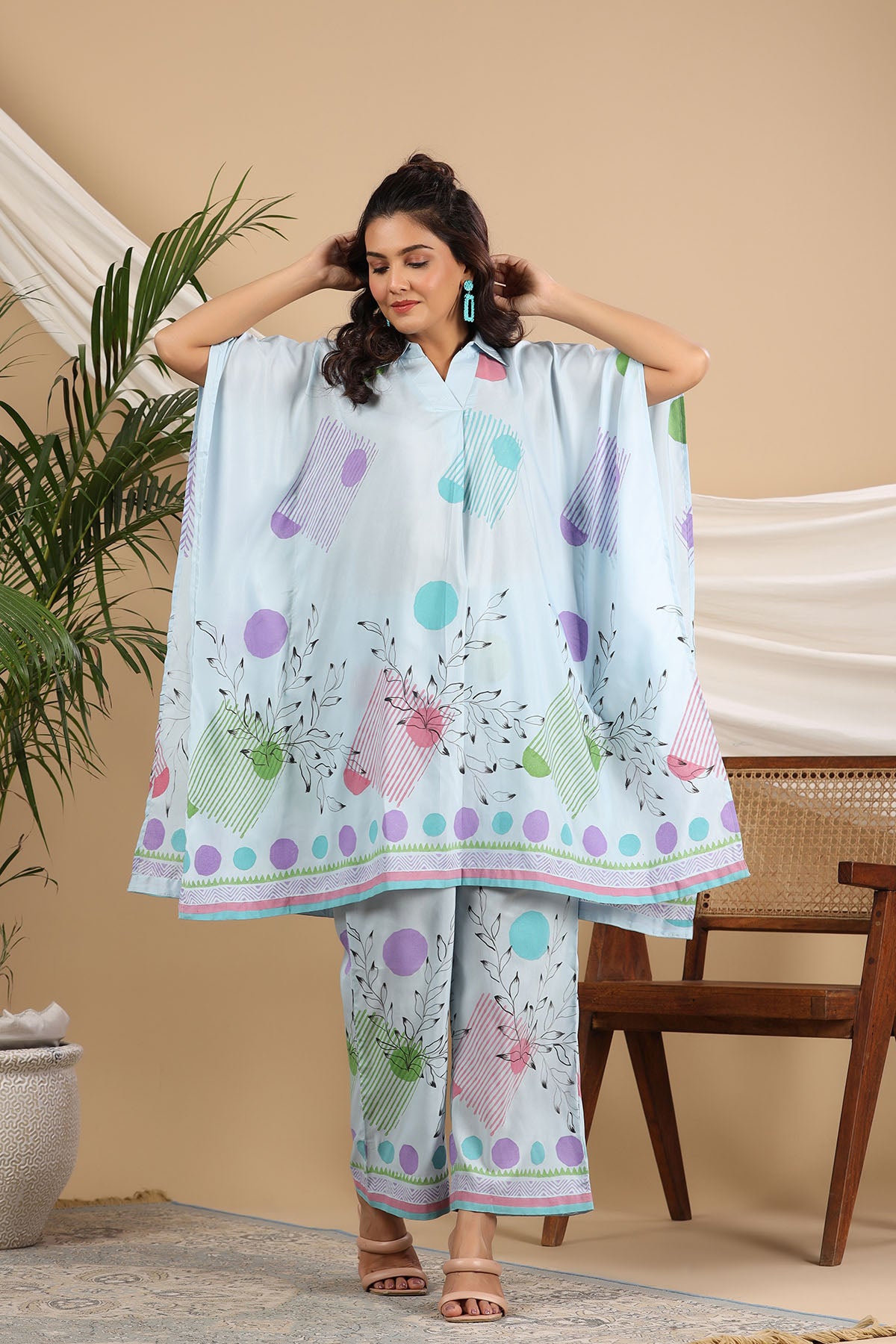Woman wearing a light blue outfit with colorful patterns in a casual setting.