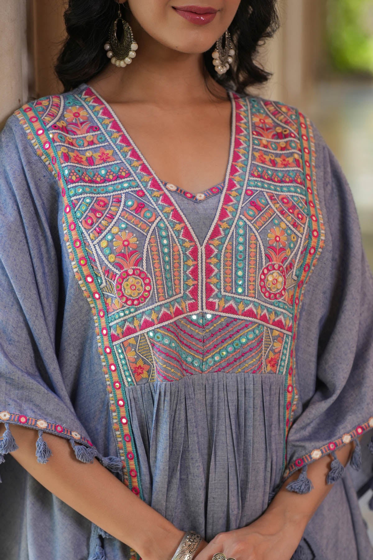 Woman wearing a traditional embroidered dress with a blurred background