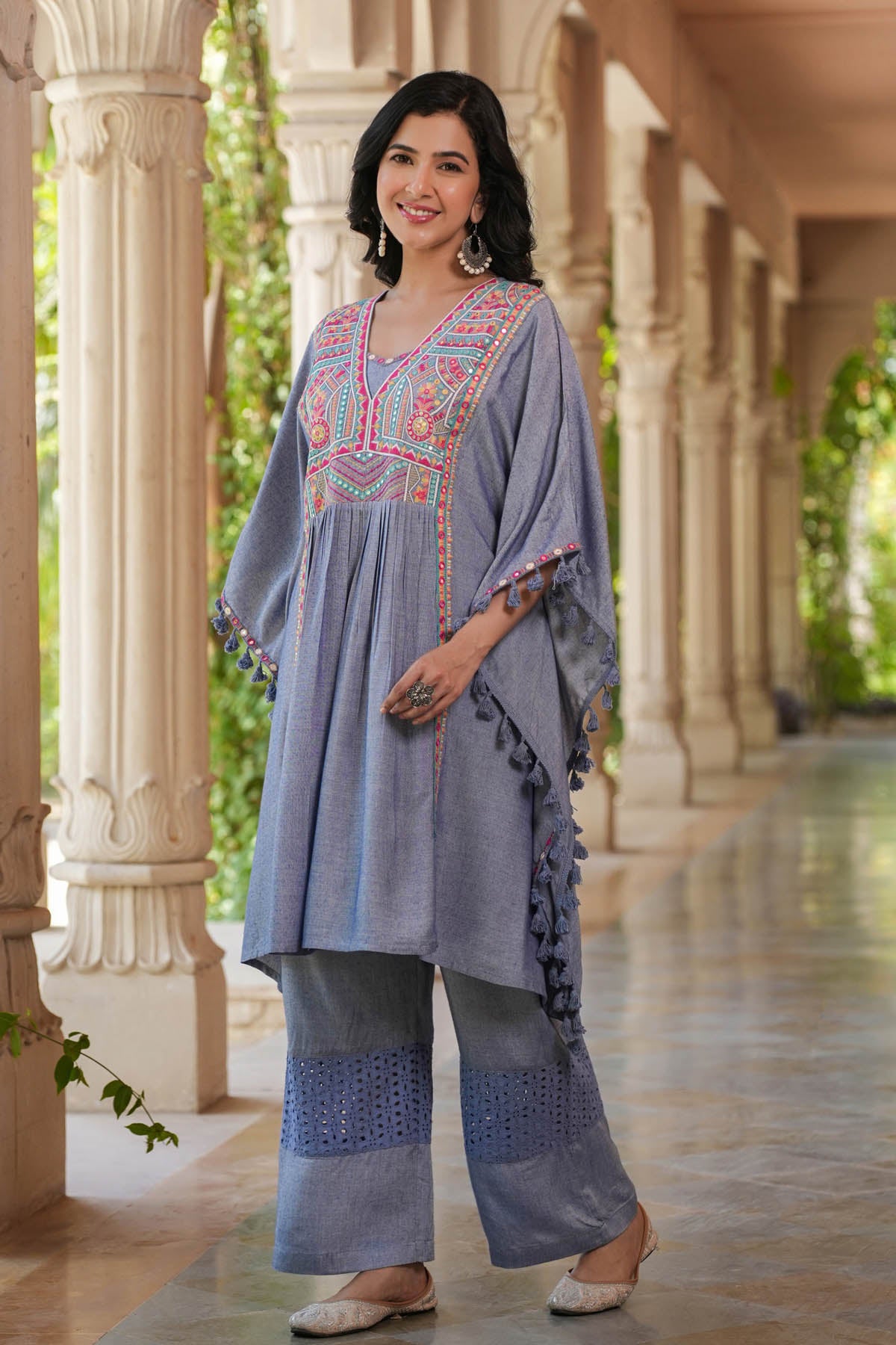 Woman in traditional embroidered outfit standing in a decorative outdoor setting