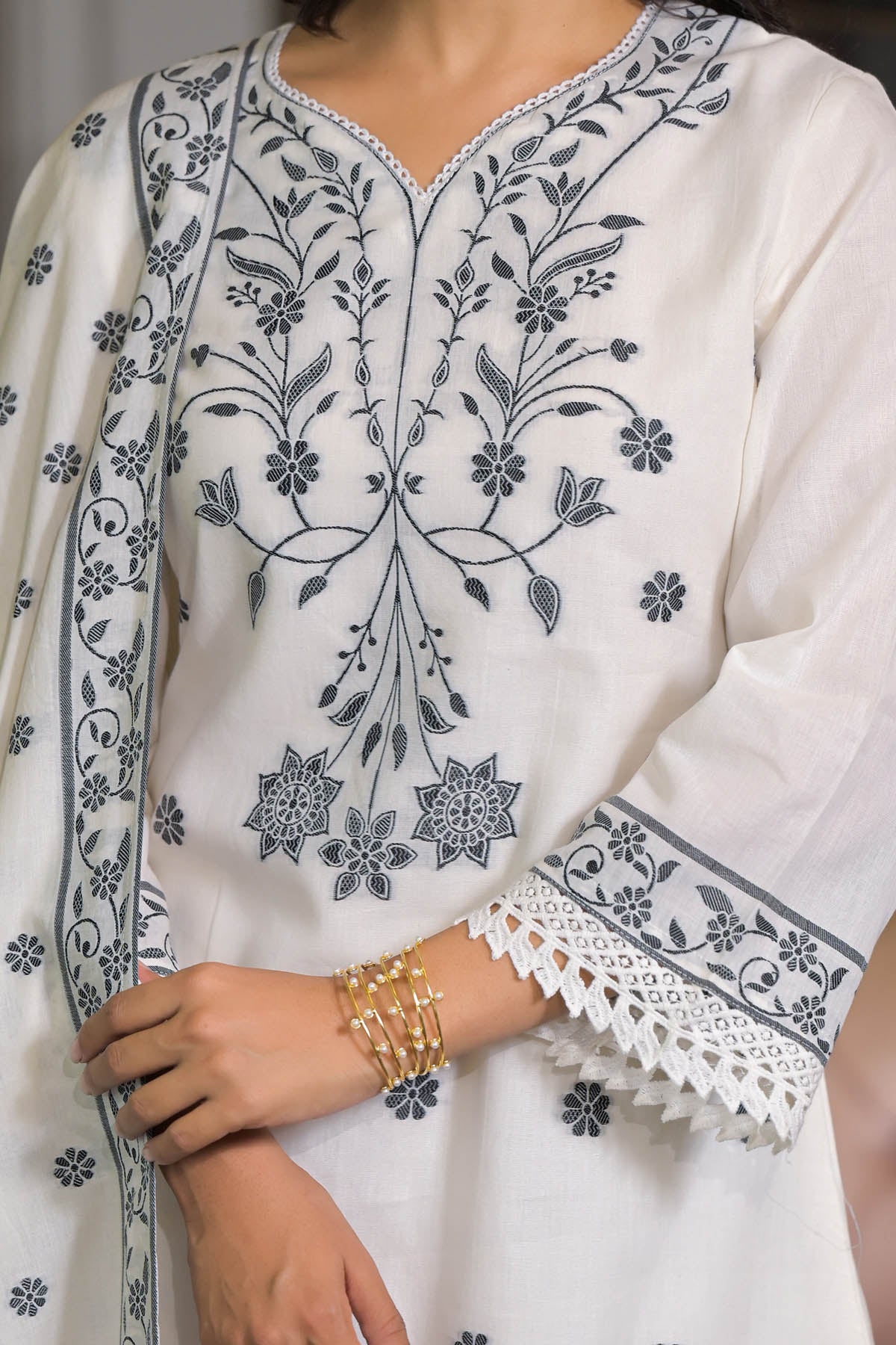 White embroidered garment with intricate patterns on a plain background