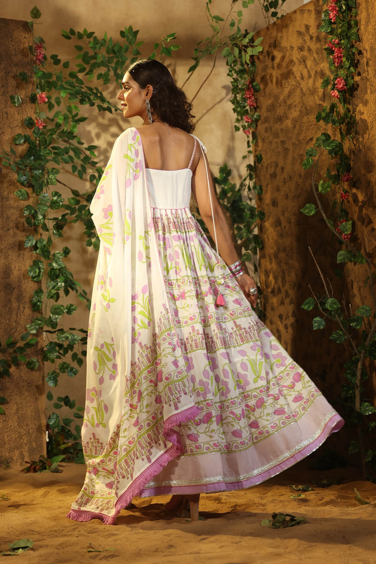 Woman wearing a floral saree with a patterned background