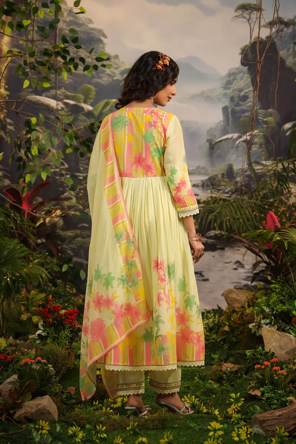 Woman in a floral dress standing in a nature-themed setting