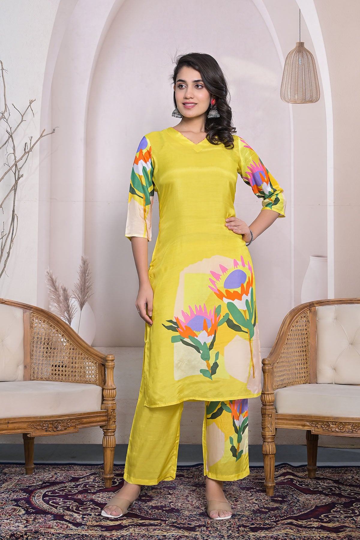 Woman wearing a yellow outfit with floral patterns in an indoor setting