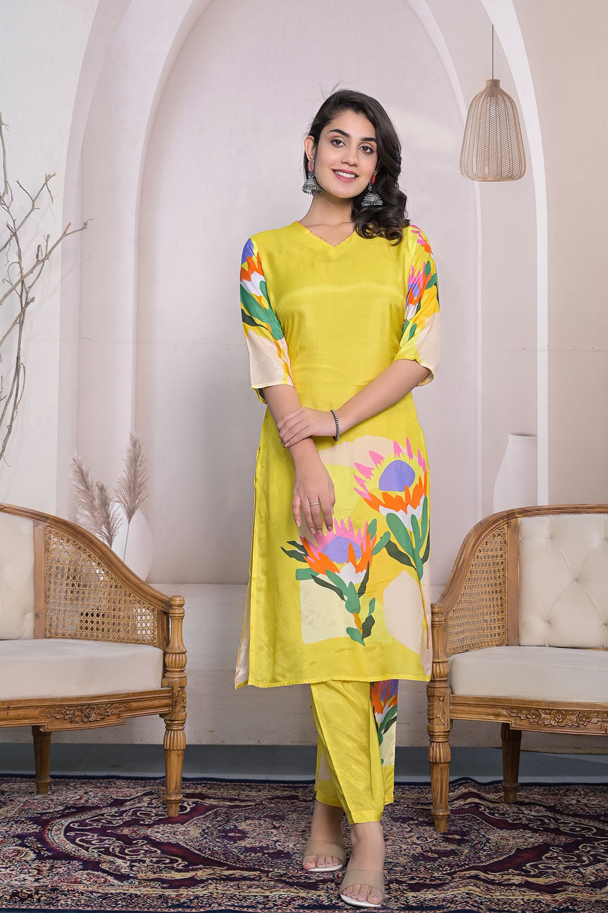 Woman wearing a yellow kurta with floral patterns in an indoor setting